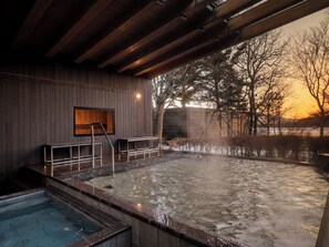A spa area with a hot tub, wooden walls, and a view of trees and a sunset. - TATESHINA LAKE RESORT (Tateshina)