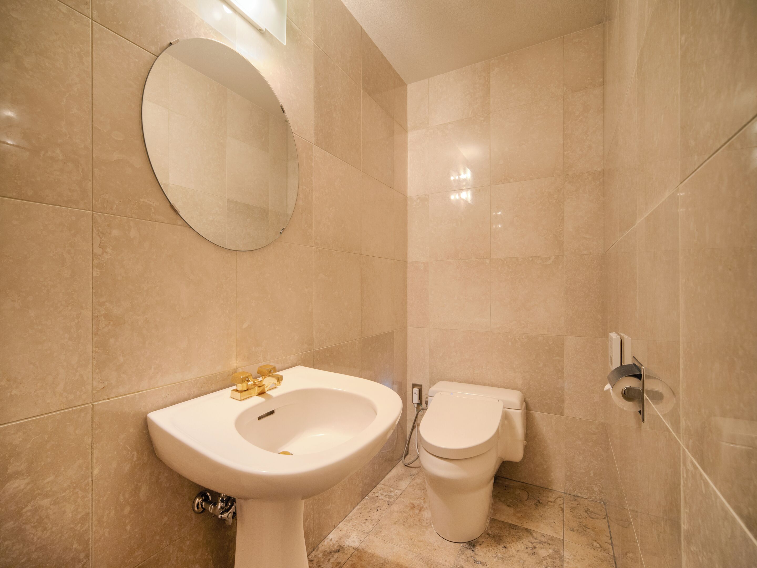 A bathroom with a sink, toilet, and a mirror.