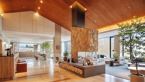 A spacious lobby with a central seating area, a wooden ceiling, and a stone accent wall. - TATESHINA LAKE RESORT (Tateshina)