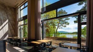 A modern interior with large windows offering a view of a lake and trees. - TATESHINA LAKE RESORT (Tateshina)