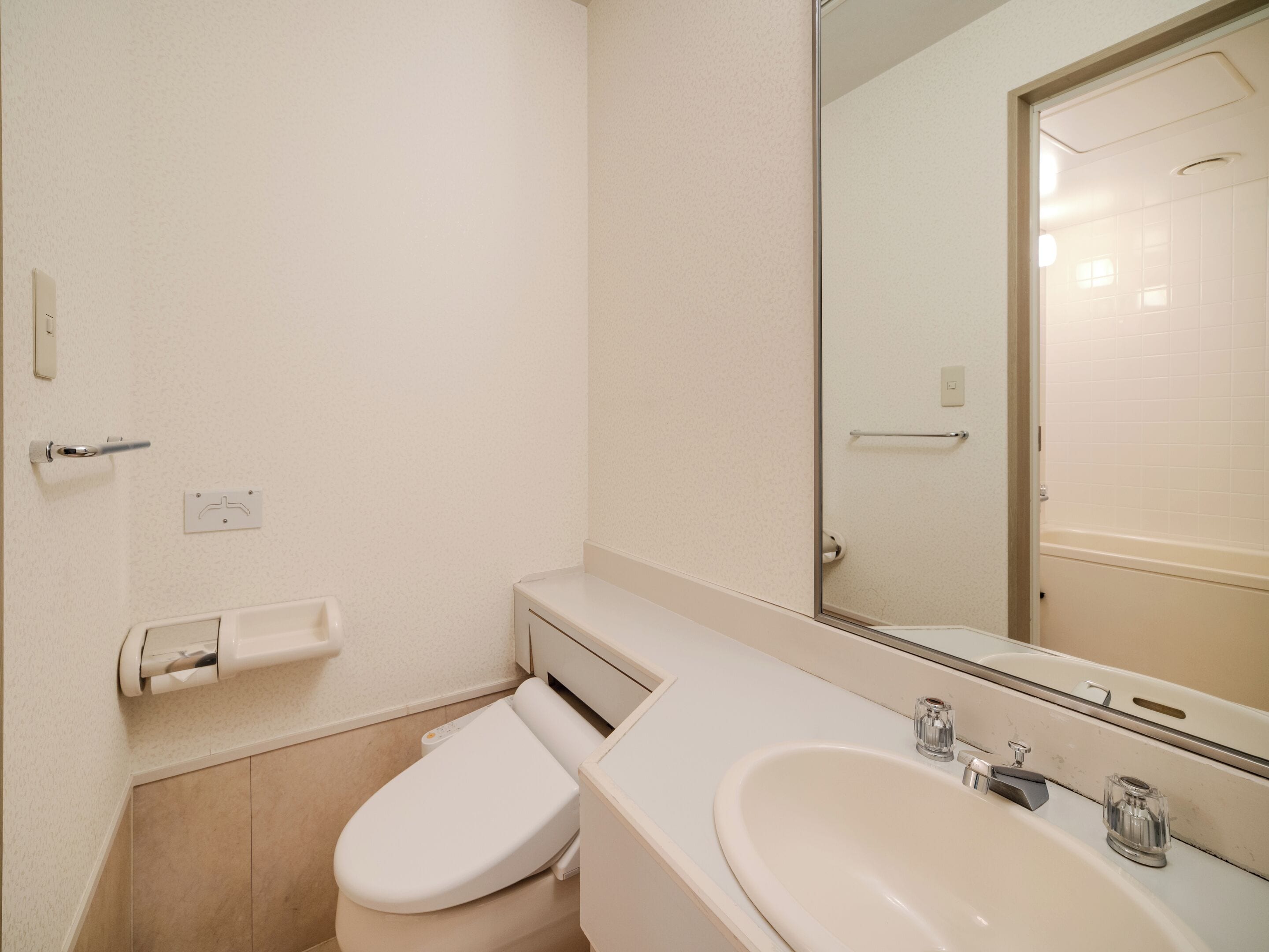 A small bathroom with a toilet, sink, and mirror.