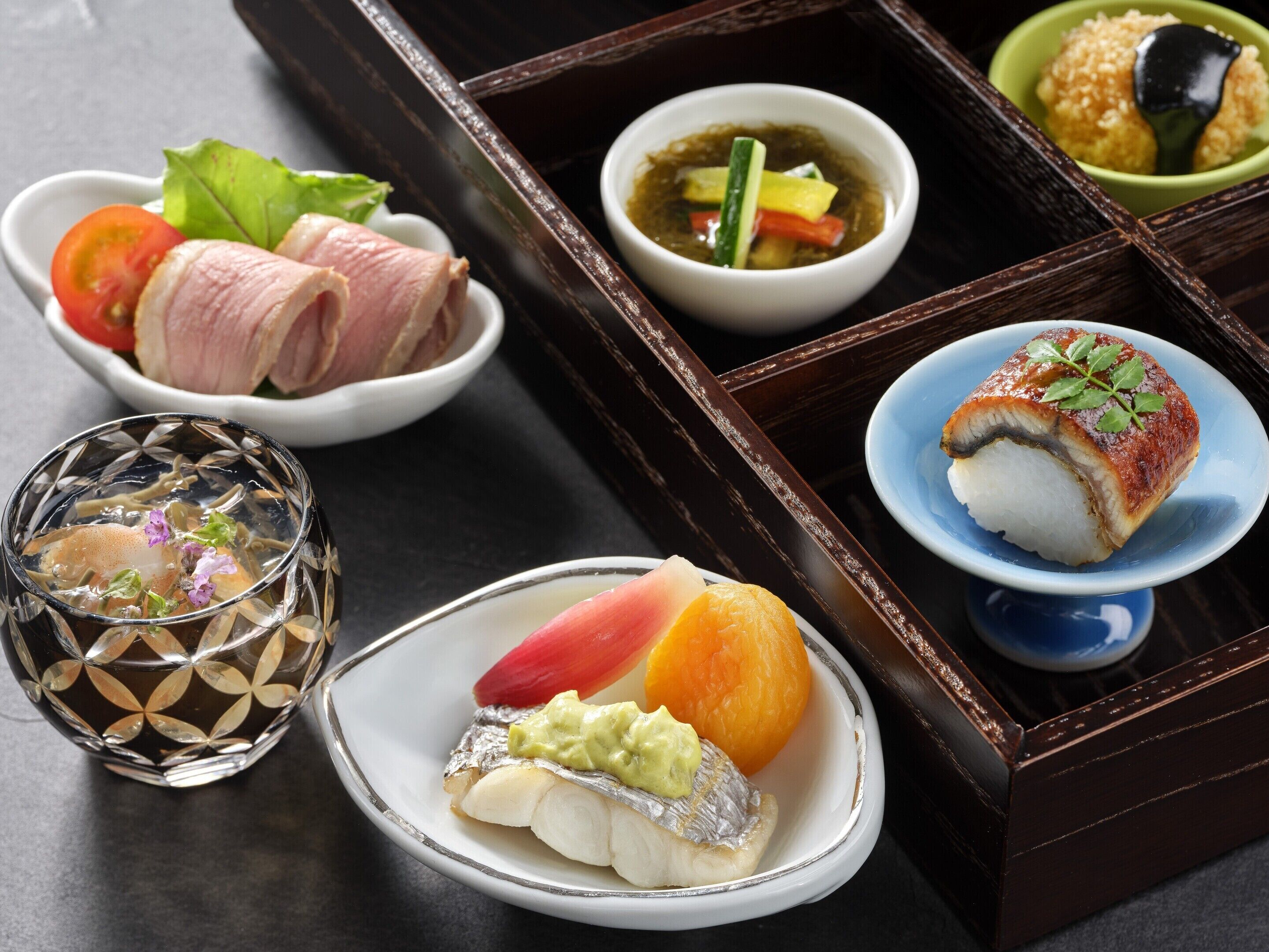 A traditional Japanese meal with sashimi, pickled vegetables, and a small bowl of soup.
