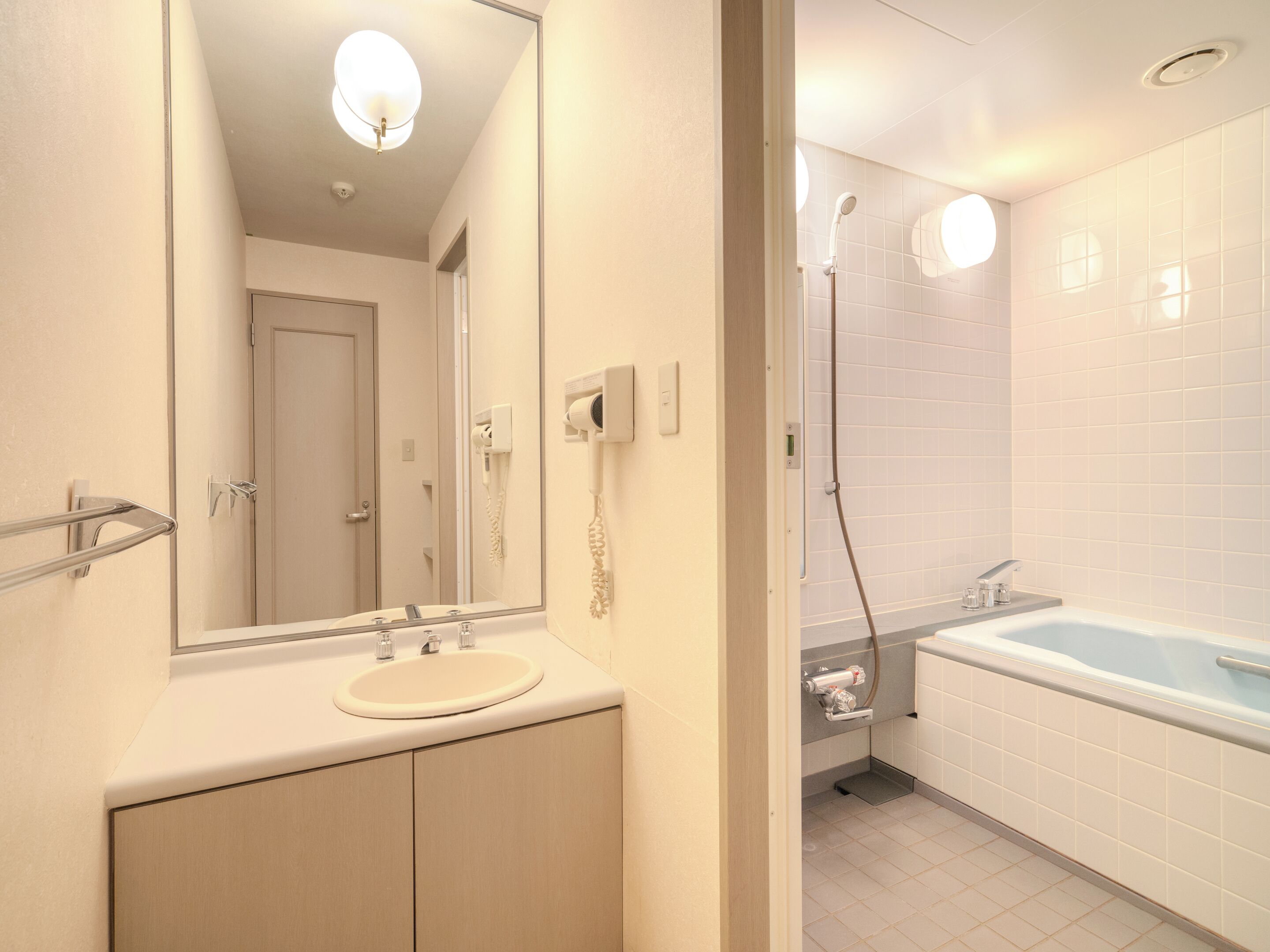 A modern bathroom with a sink, mirror, and shower.