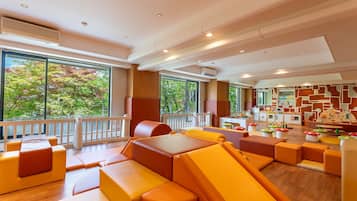 A modern interior with seating areas, large windows, and a view of trees.