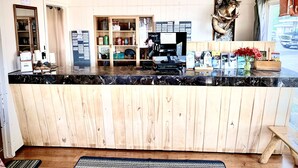 A reception desk with a wooden panel design, a computer, and a cash register. - Forest Lake Motel (Grand Rapids)