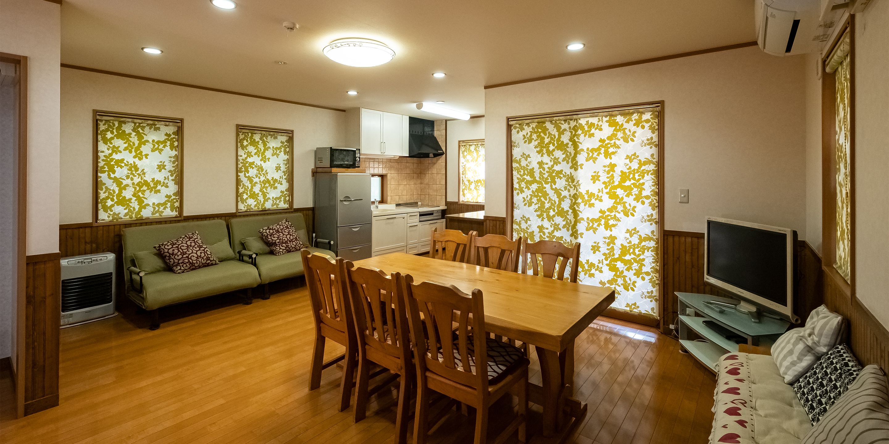 A compact living space with a dining area, kitchenette, and seating area.
