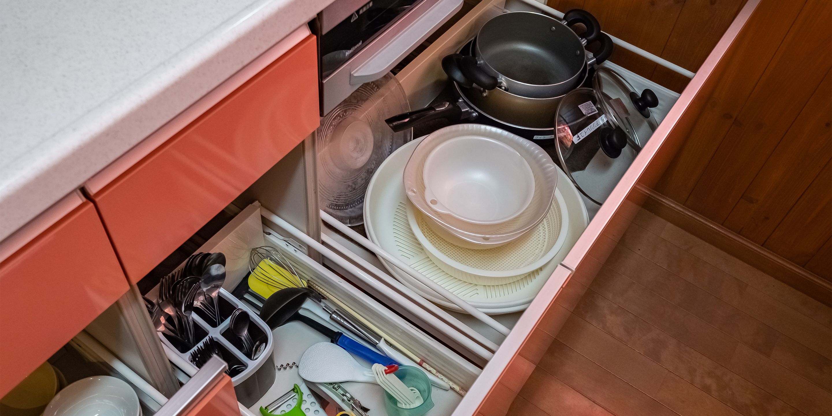 A kitchen drawer with various utensils and cookware.