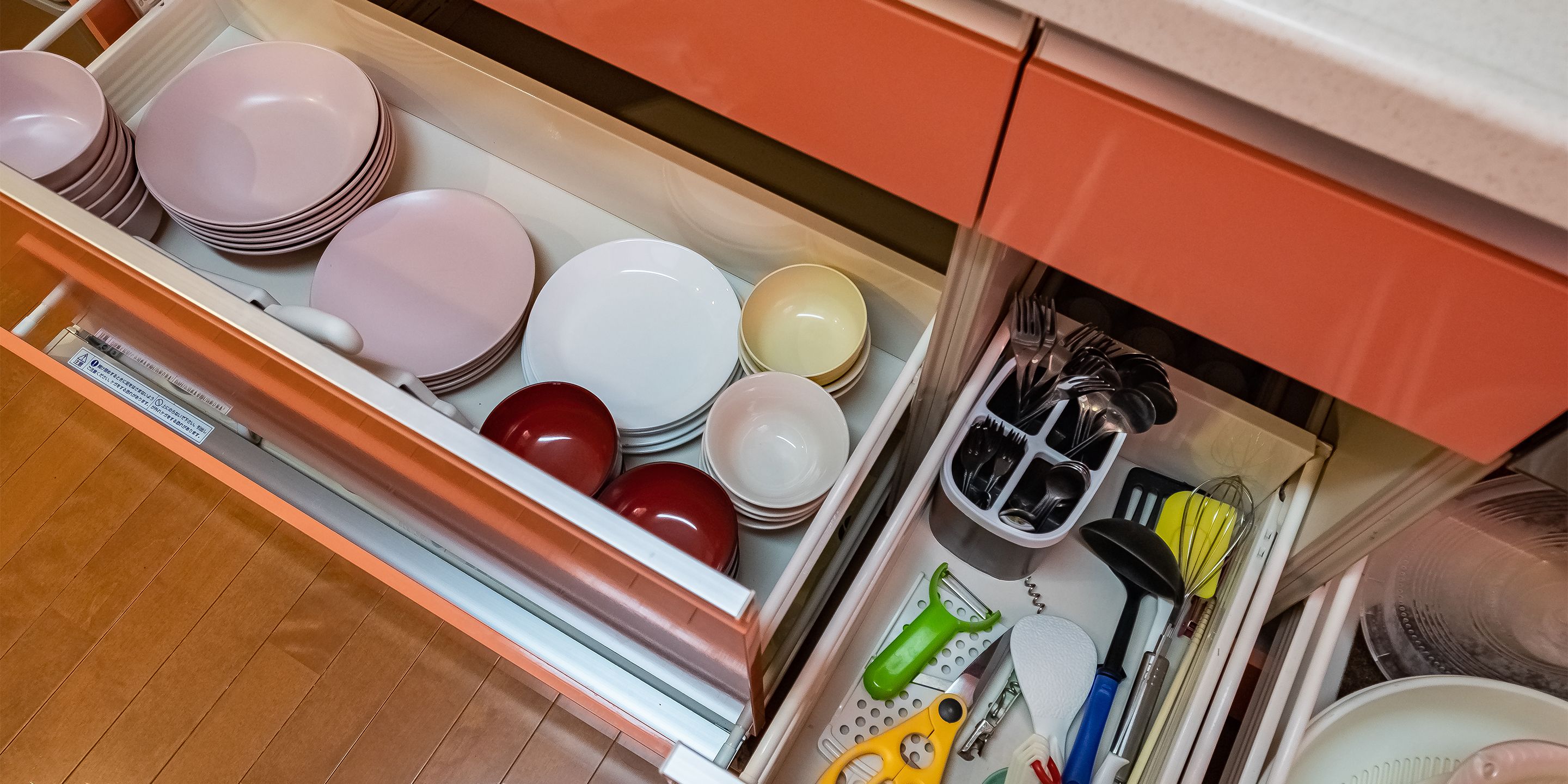 A drawer with stacked plates and cutlery.