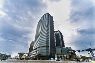 A tall, modern building with a curved facade and large windows.