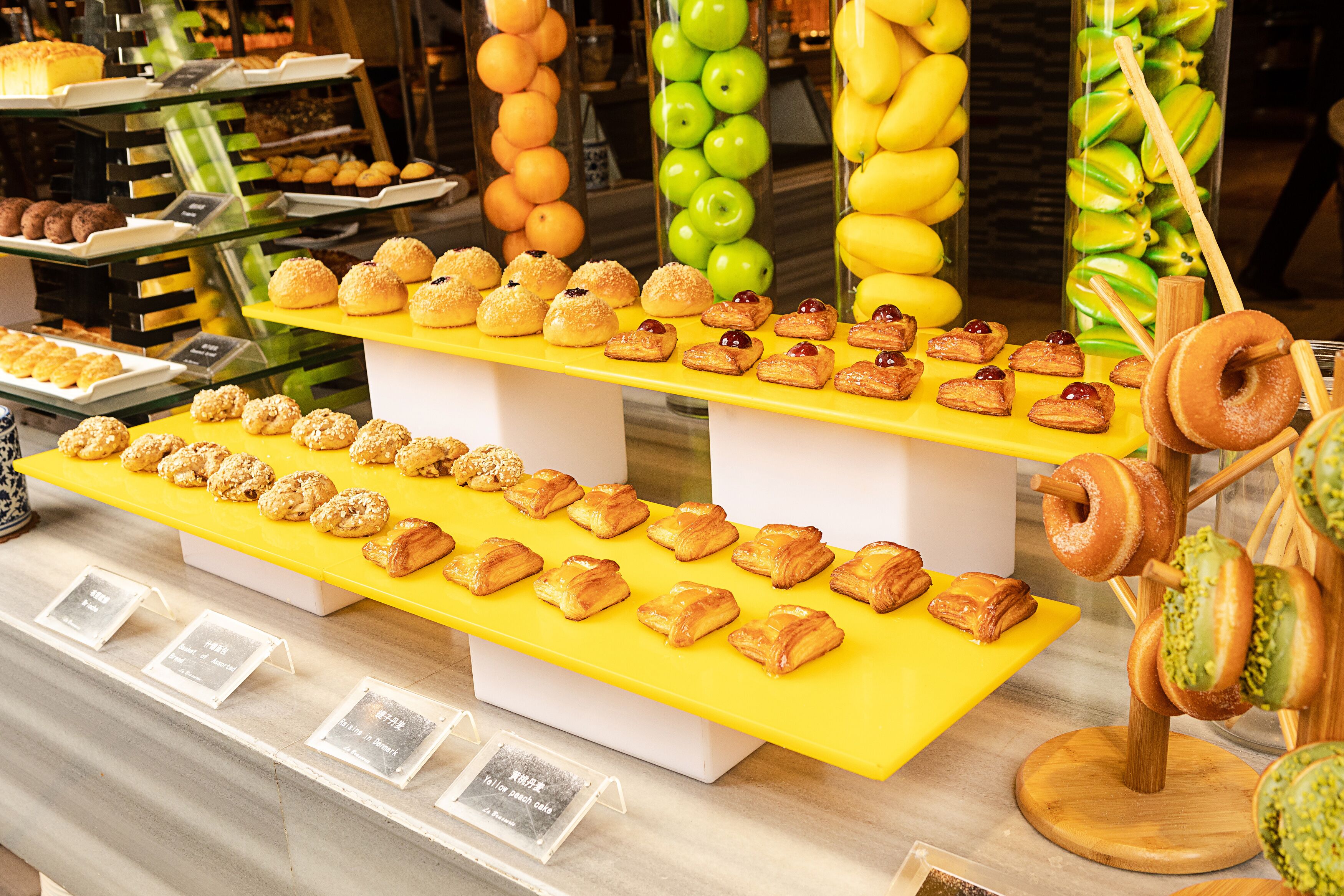 A bakery display with various pastries and fruits.
