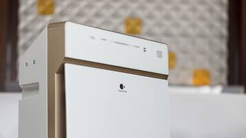 A white refrigerator with a barcode and a QR code on the top, placed on a carpeted floor.