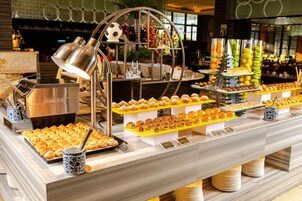 Un bufé con diversas opciones de pastelería y una máquina de café.