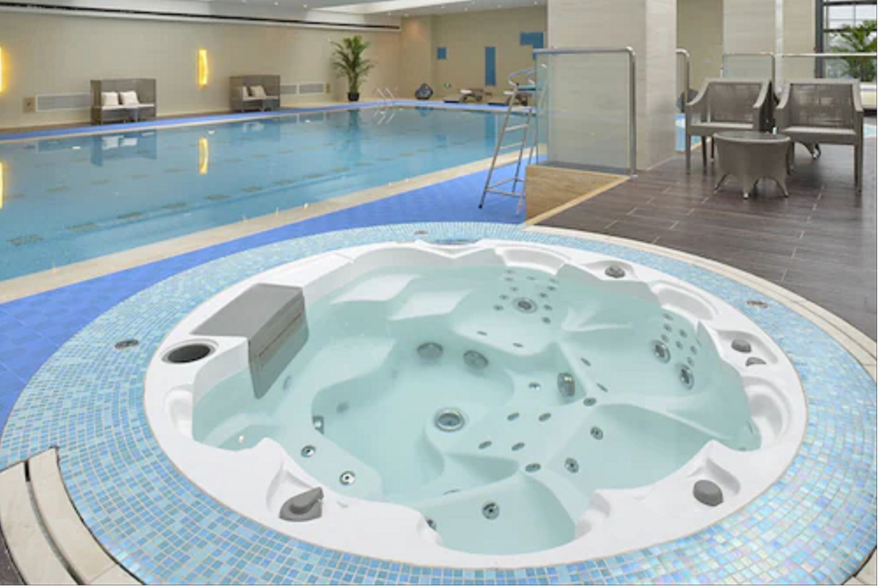 Una piscina interior con un jacuzzi al frente.