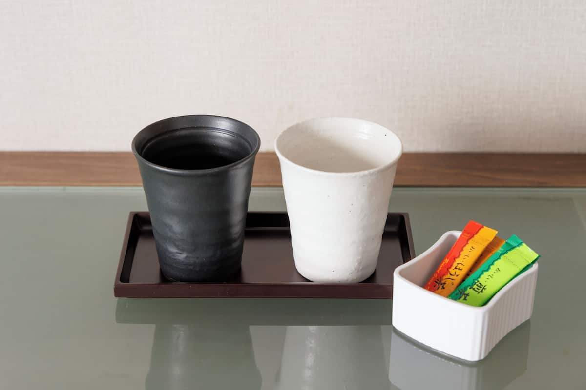 A tray with two cups and a container holding colorful cards.