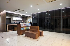 A modern reception area with a wooden reception desk, a seating area with a bench, and a glass partition. - Hotel Sardonyx Ueno (Tokyo)