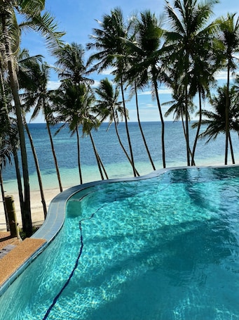 Una piscina al aire libre, sillones reclinables de piscina