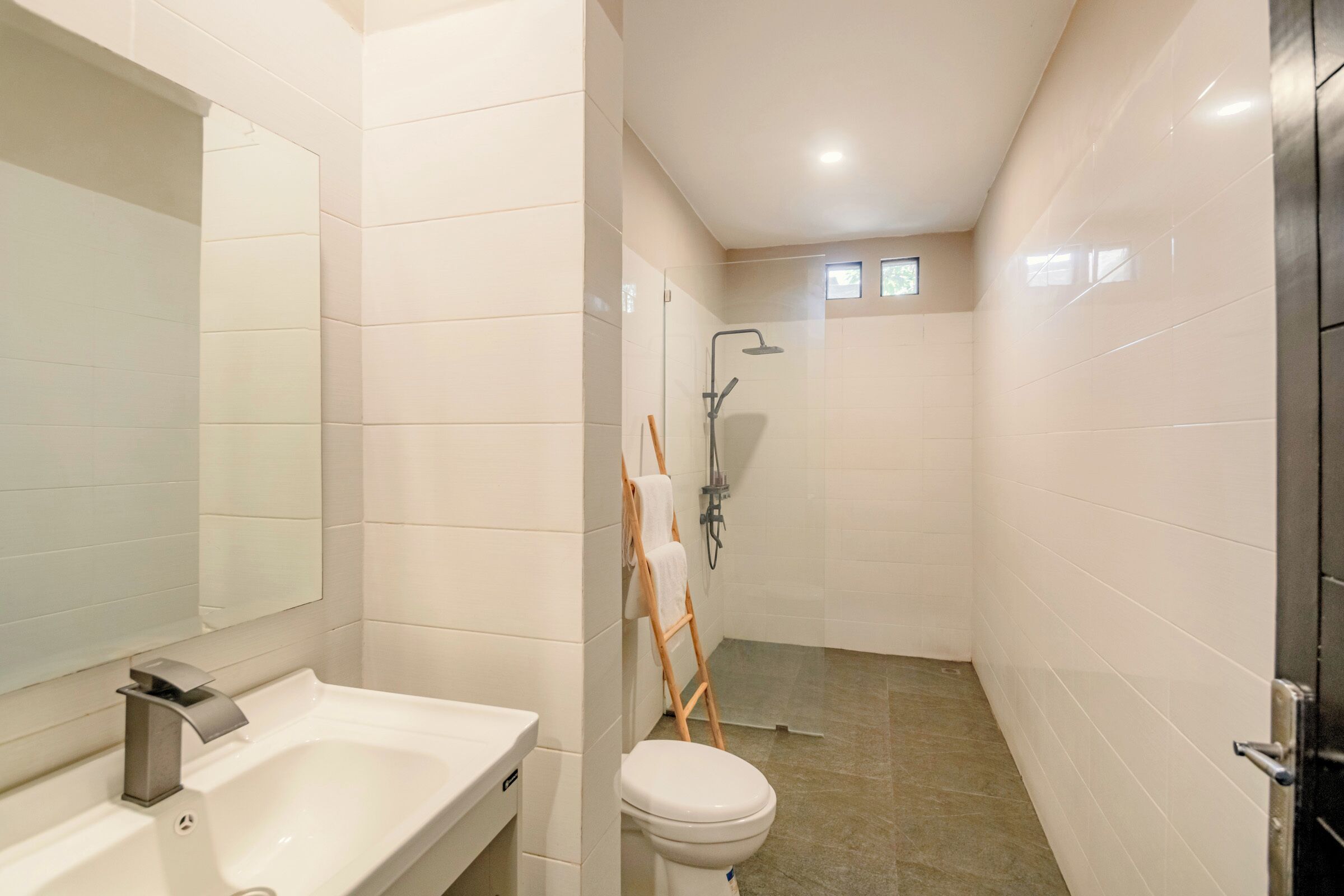 A bathroom with a white sink, a toilet, and a shower area.