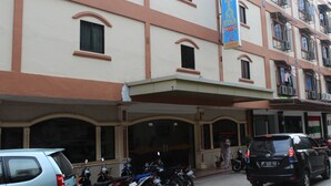A hotel with a signboard, multiple windows, and parked vehicles. - Batam Star Hotel (Batam)