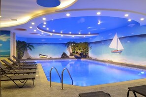 Een binnenzwembad, een buitenzwembad en parasols bij het zwembad