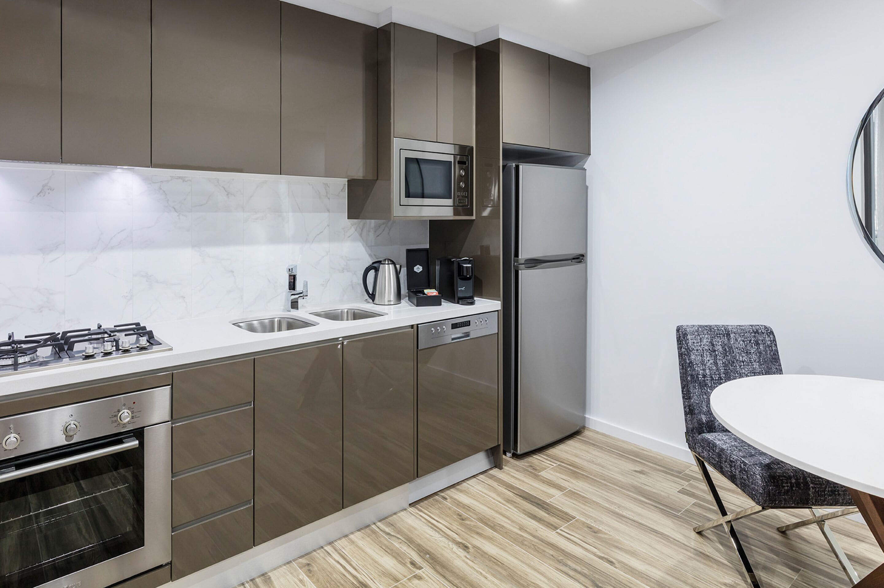 Una cucina moderna con elettrodomestici in acciaio inossidabile, un forno a microonde integrato e una macchina da caffè.