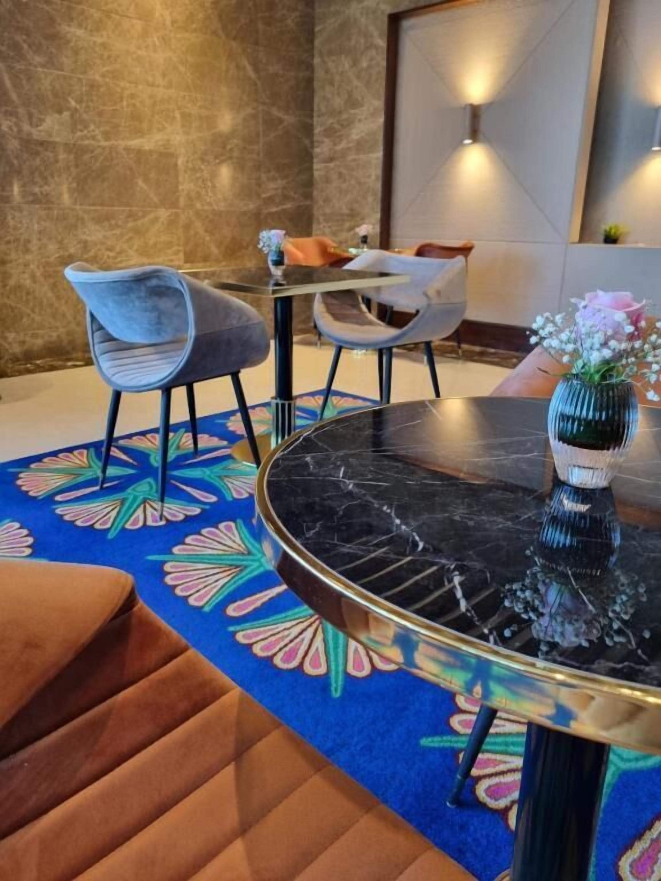 A dining area with a round table, chairs, and a decorative rug.