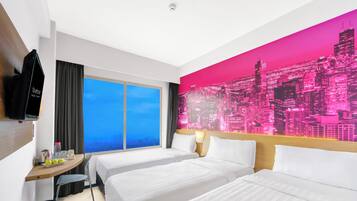 Habitación de hotel con dos camas, un mural de paisaje urbano, un televisor y una ventana con cortinas.