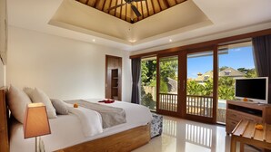 Un dormitorio con cama, mesita de noche, lámpara, televisor y balcón con vistas al exterior.