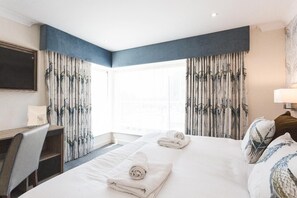 A hotel room with two beds, a desk, and a chair. - The Nottinghamshire Hotel and Golf Club (Nottingham)