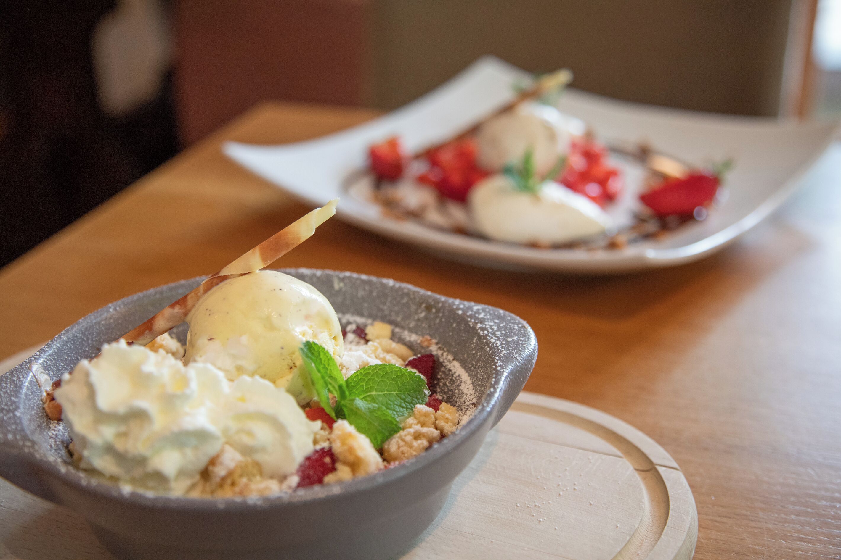 Un postre con helado y bayas sobre un plato.