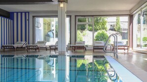 Una piscina con sillas de descanso y vistas al exterior.