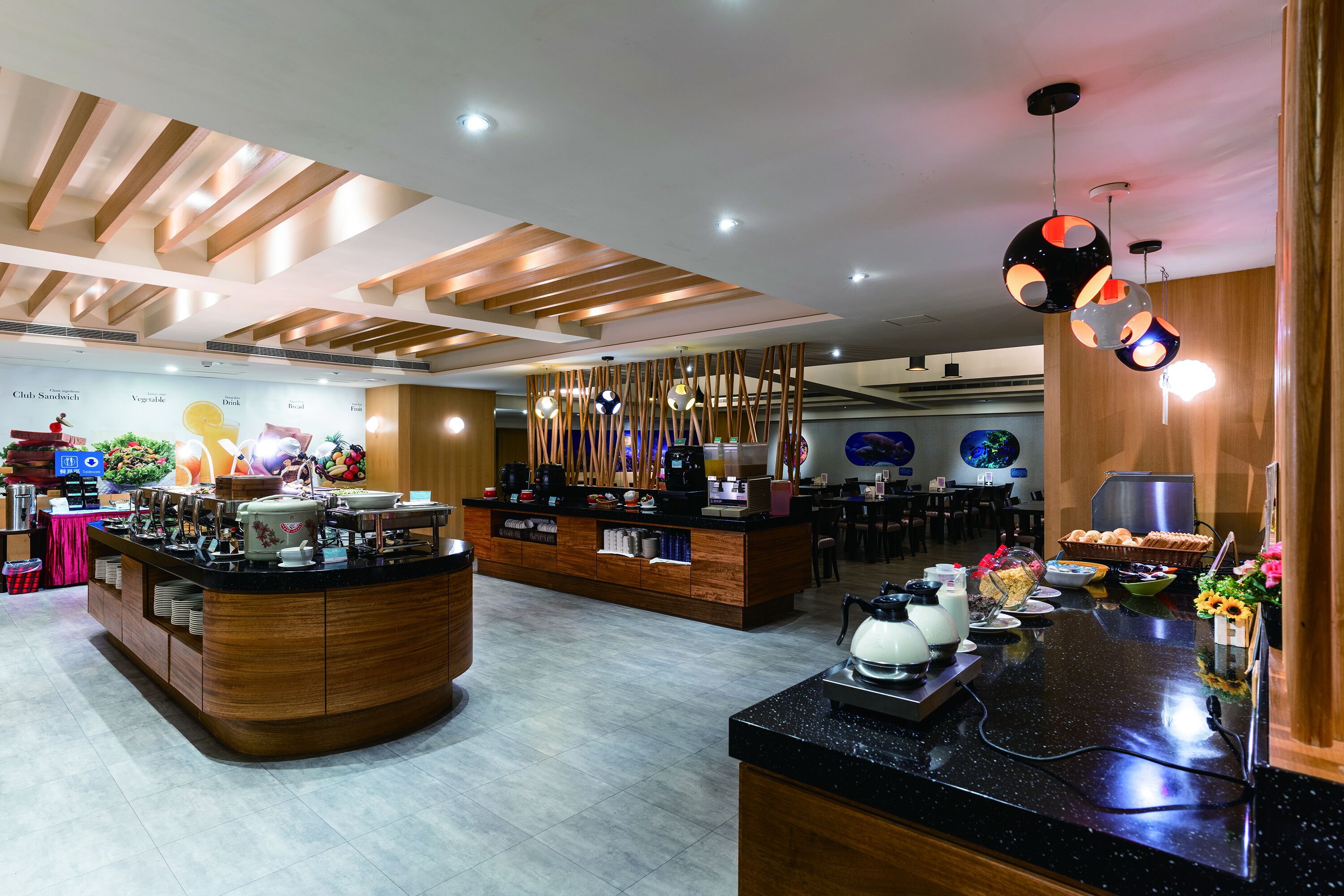 A modern cafe with a wooden counter, a coffee machine, and a variety of food items.