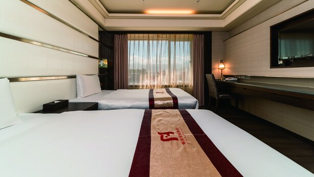 A hotel room with two beds, a desk, a chair, a TV, and a window with curtains. - Fish Hotel - Taitung (Taitung)