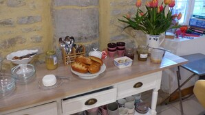 Un plan de travail de cuisine avec du pain, des ustensiles et un vase de tulipes.