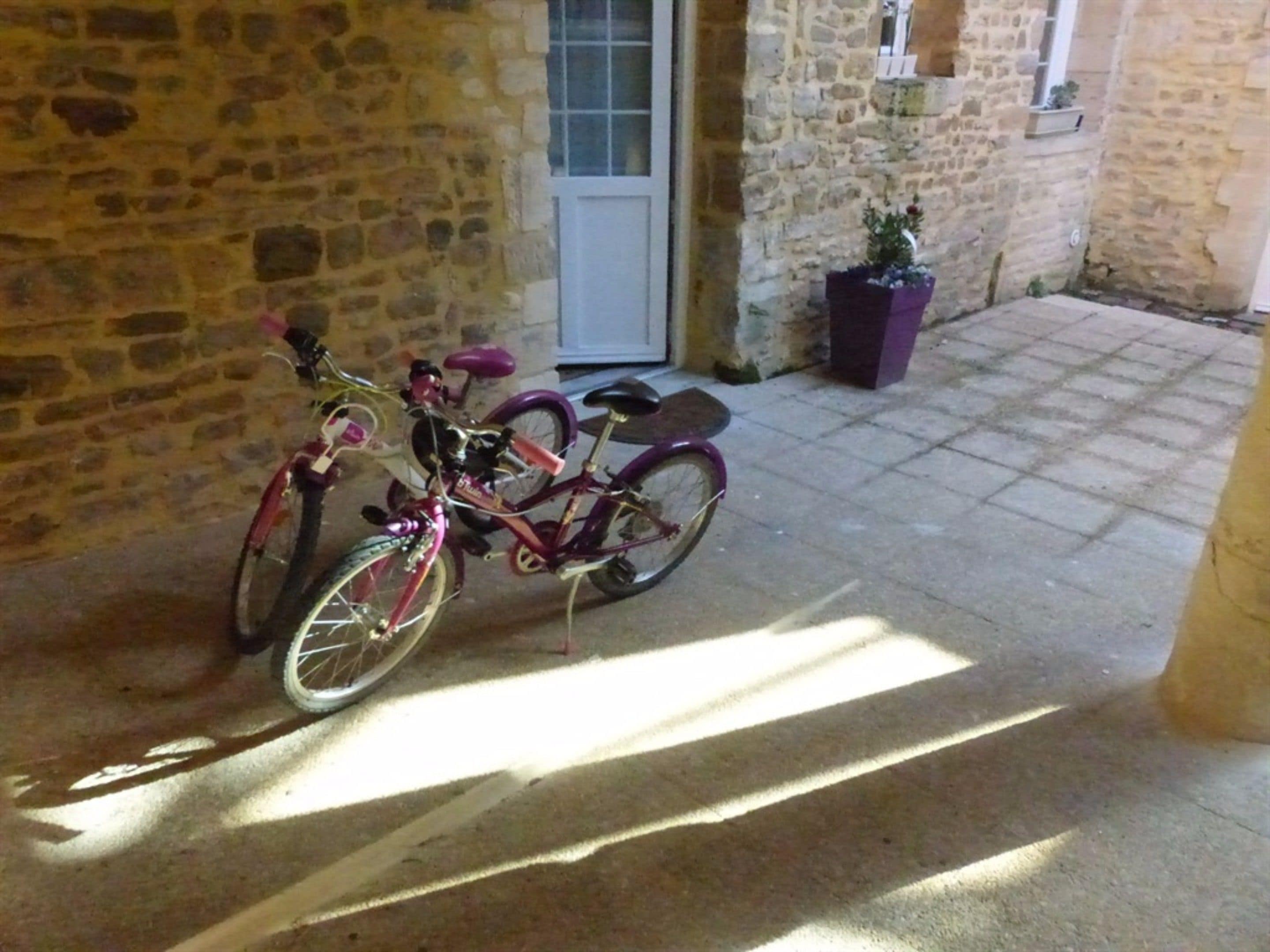 A stone building with a door and a window. There is a bicycle parked in front of the building.