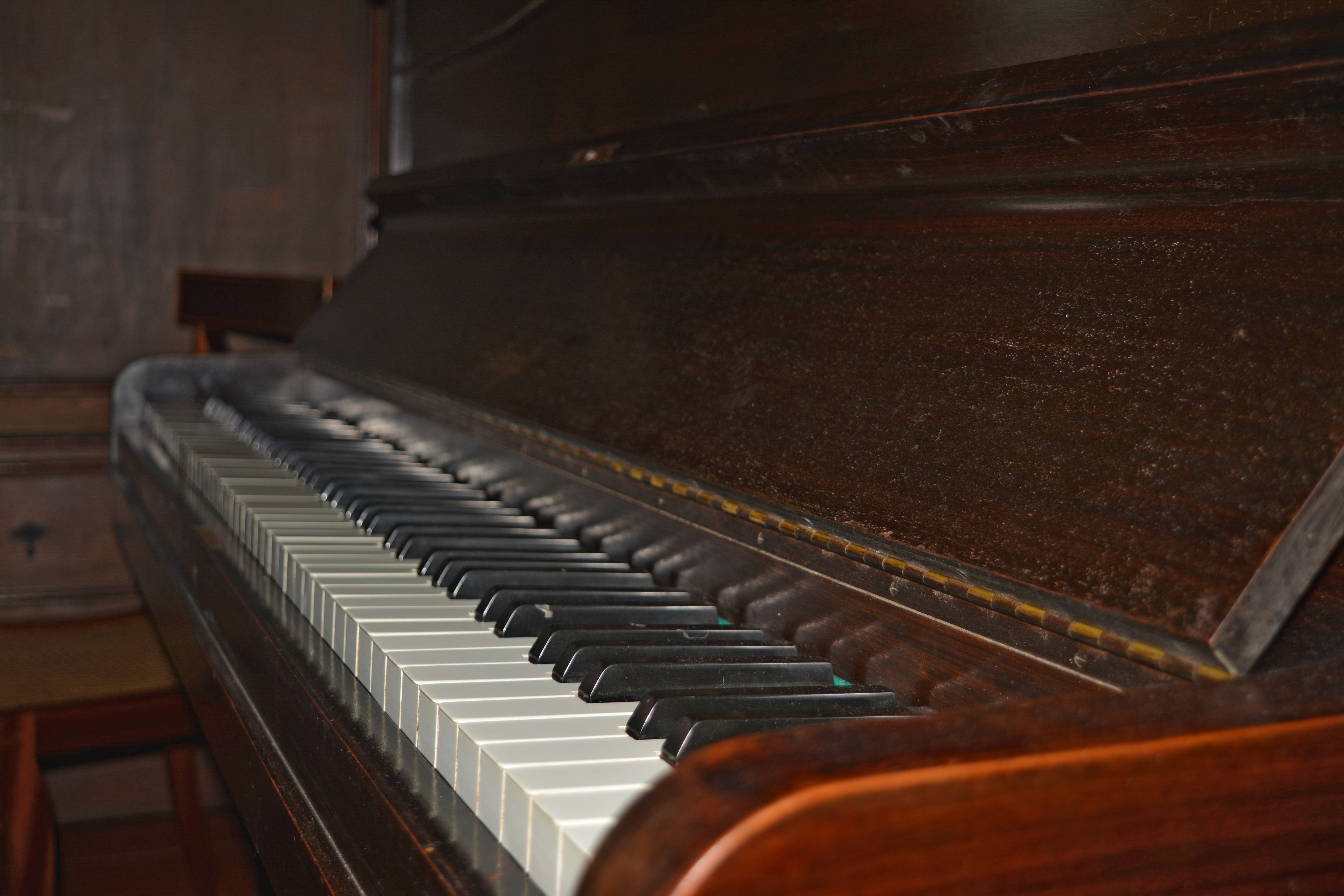 A close-up of a piano with a wooden finish and black and white keys.