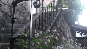 A stone building with a staircase leading to a second floor.