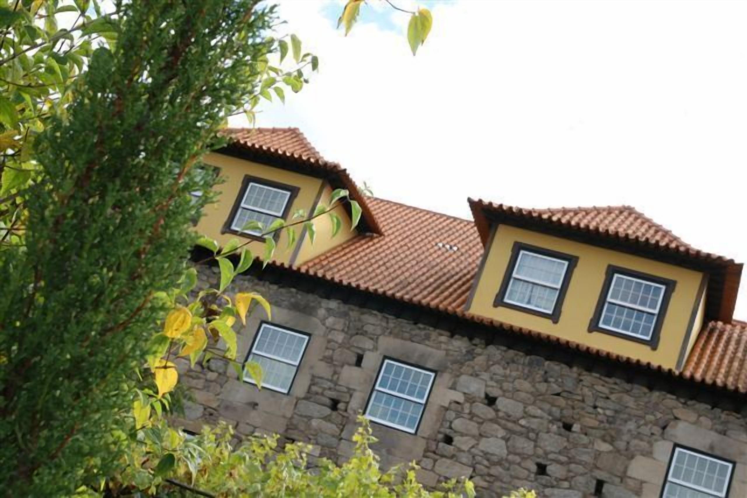 Um edifício de dois andares com fachada de pedra e exterior amarelo.