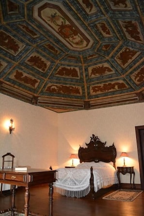 A room with a wooden bed, a desk, and a chair. The ceiling has a geometric pattern. - Solar dos Correia Alves (Moimenta da Beira)