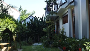 A pathway leading to a building with a garden and a small pond. - Hoi An Osaka Riverside Villa & Spa (Da Nang)