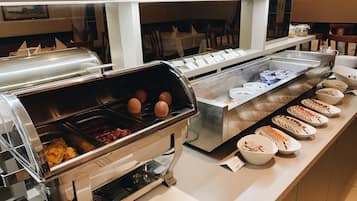 Un bufé con diferentes opciones de comida y una estación de autoservicio.