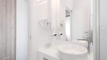 A modern bathroom with a large mirror, white sink, and a towel rack.