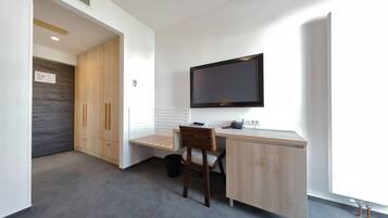 Un espace de bureau moderne comprenant un bureau, une chaise et un téléviseur à écran plat fixé au mur.
