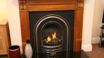A fireplace with a black surround and a wooden mantel.