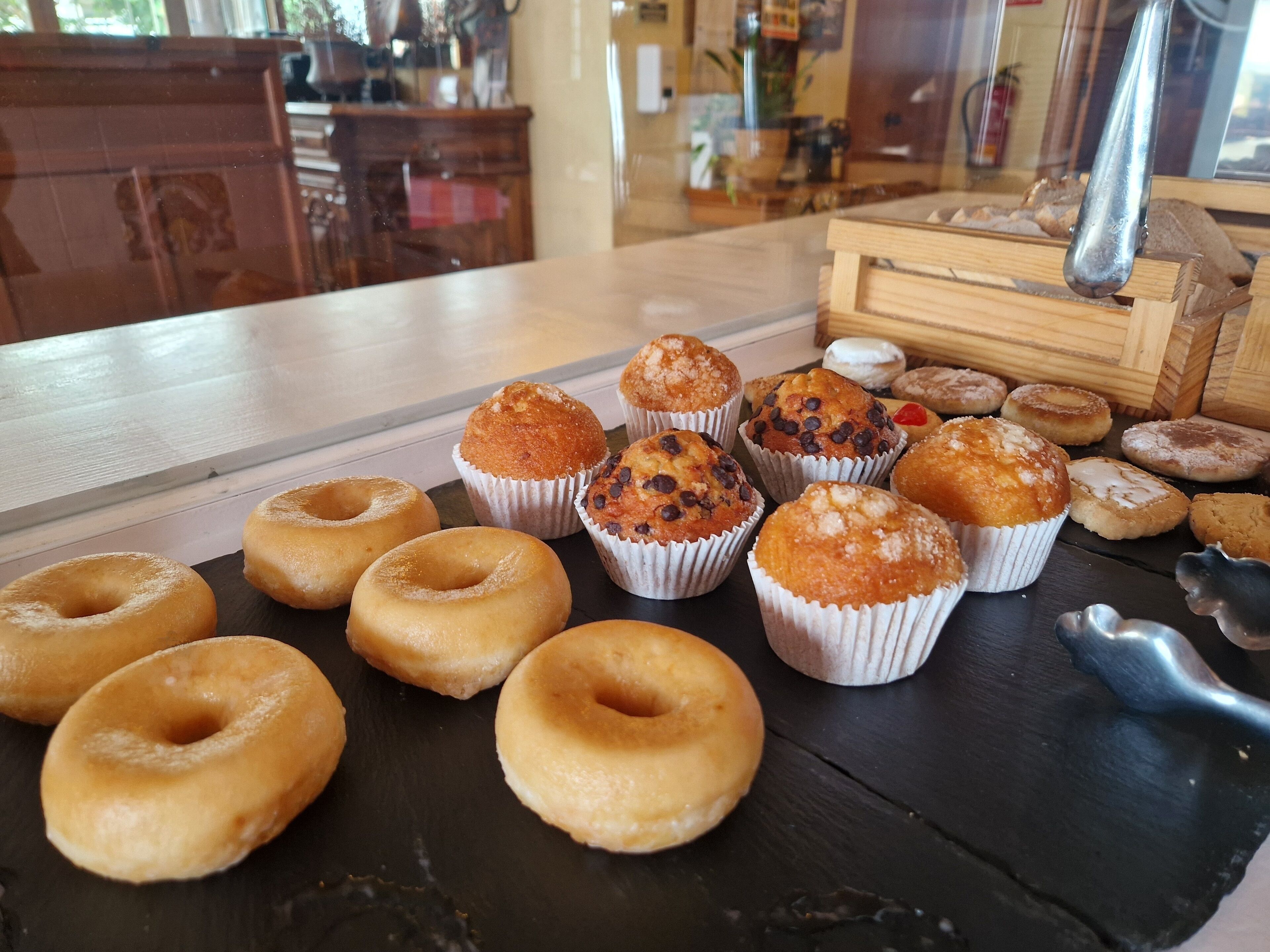 Verschiedene Backwaren auf einem Holztisch in einem Café.