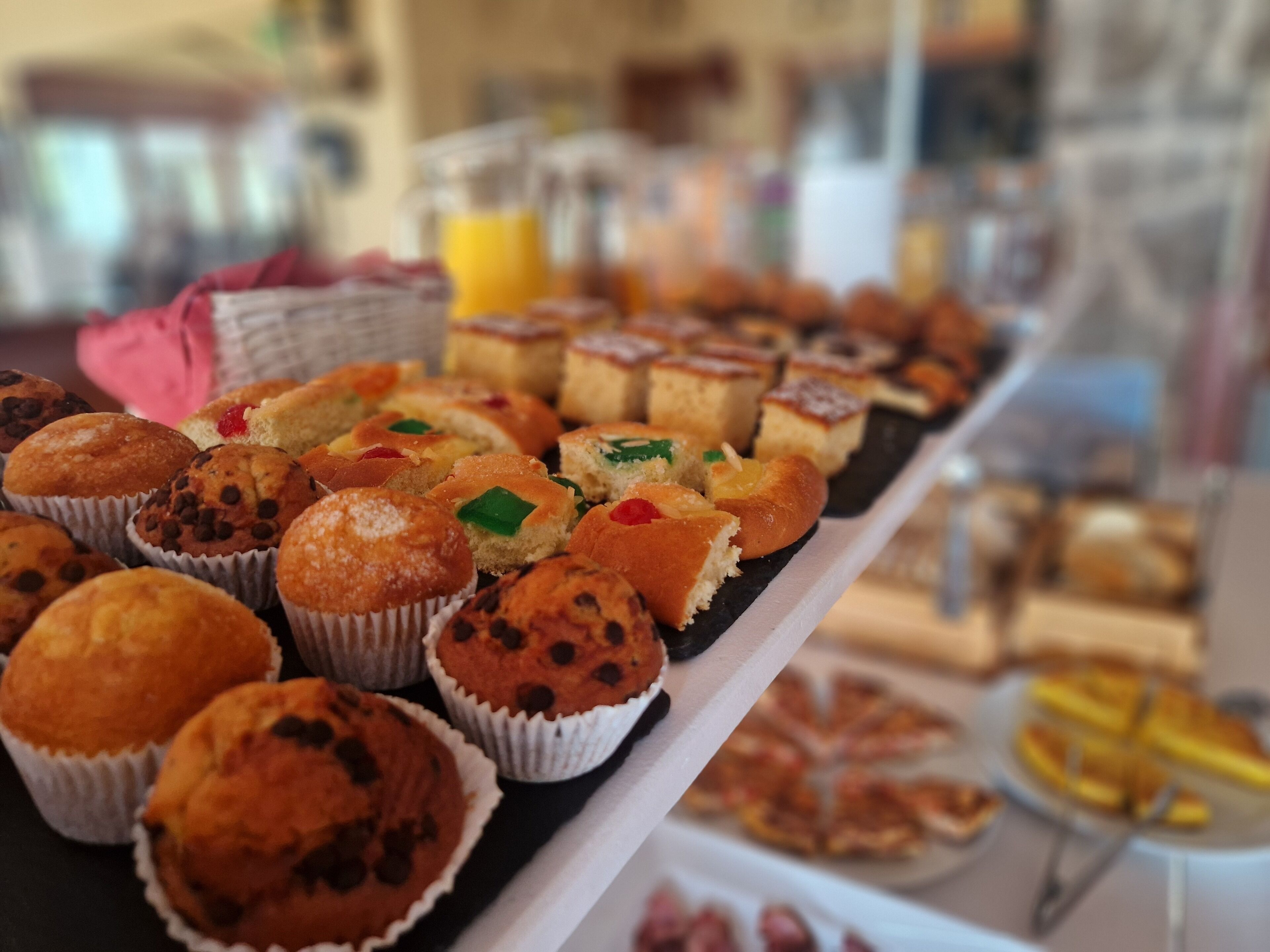 A buffet with various baked goods including muffins and pastries.