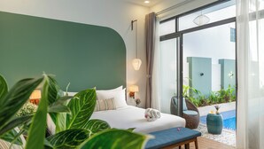 A hotel room with a bed, bedside lamps, a bench, a view of a swimming pool, and potted plants. - Volar Hoi An (Da Nang)