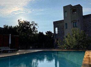 A swimming pool with a modern building in the background. - Hotel Miramonti (Fasano)