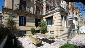 A courtyard with outdoor furniture, a stone floor, and a staircase leading to an upper floor. - Ibaia Et Arramak (San Sebastián)