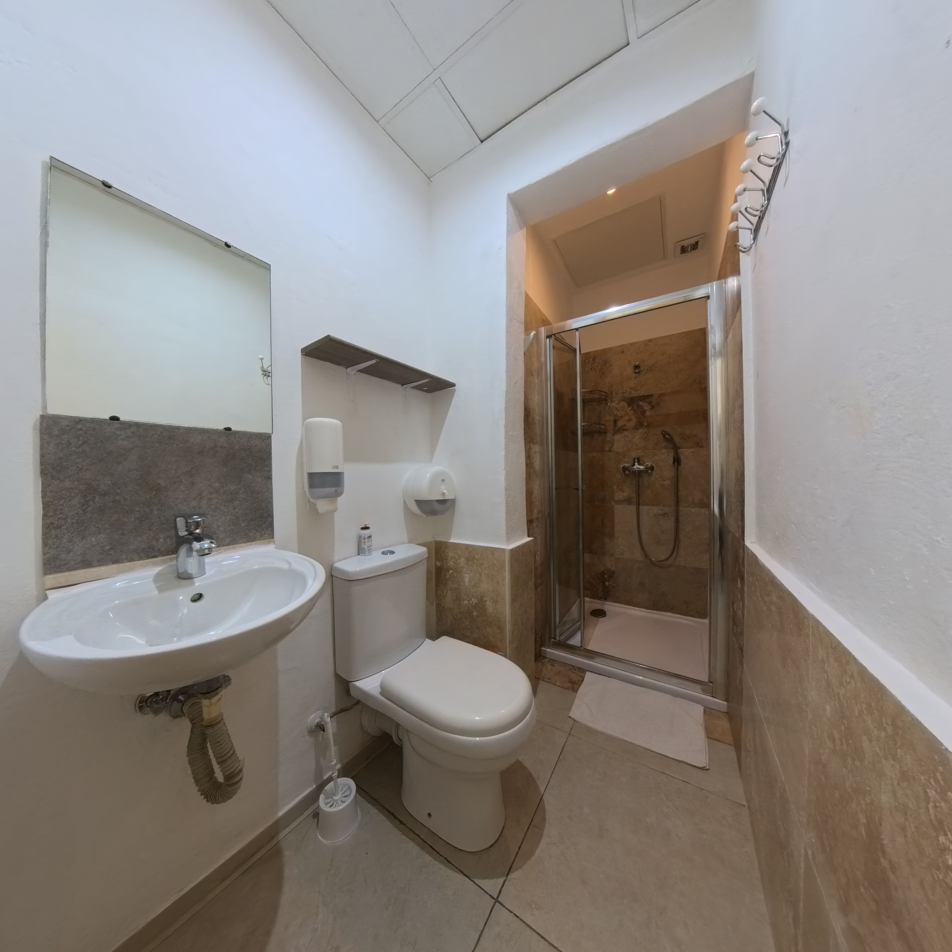 A bathroom with a sink, toilet, and shower.