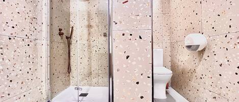 A modern bathroom with a shower, toilet, and a glass-enclosed shower area.